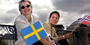 En kvinde med det svenske flag og en ung mand med det norske flag