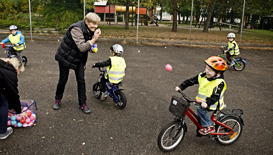 Voksen kaster bolde efter cykelkurve hos børn under cykelleg i den integrerede institution Valnødden i Hvidovre. 