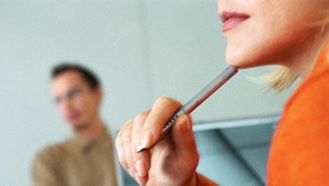 Kvinde sidder med blyanten ved hagen