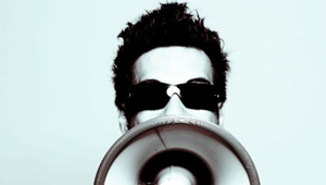 Mand råber i meagfon