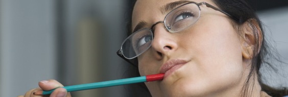 Kvinde der tænker med en blyant i munden
