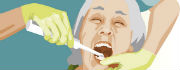 Tandplejer børster tænder på ældre kvinde