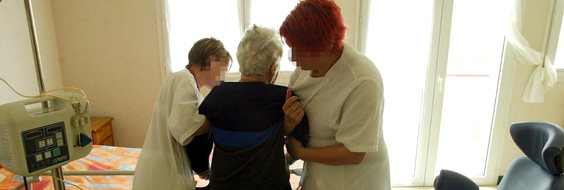 Plejepersonale hjælper ældre kvindelig patient